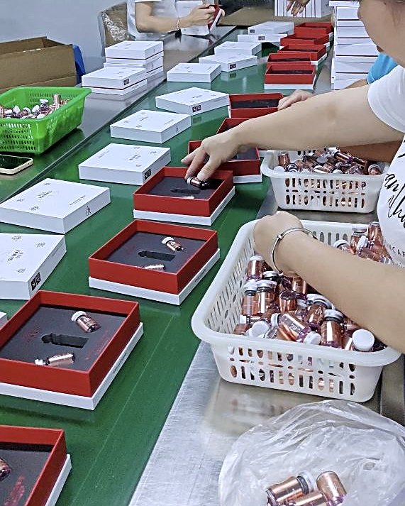 Copper ampoules being assembled into gift boxes by hand